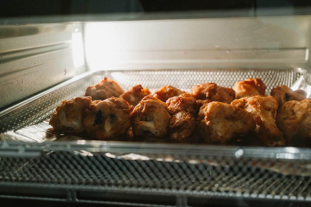 Golden fried chicken bites cooking in an air fryer basket