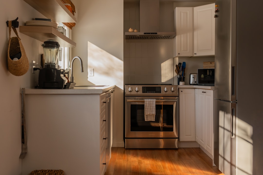 A small apartment kitchen with an island counter, blender, and gas stove