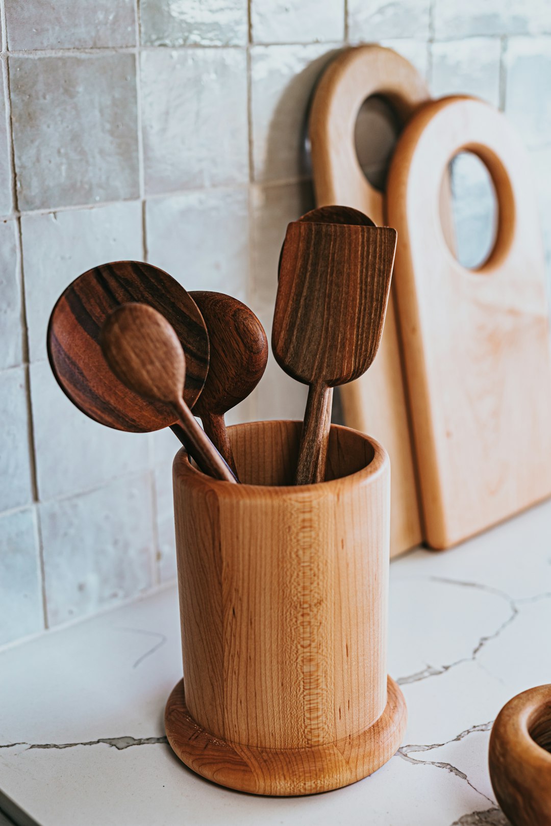 A set of wooden cooking spoons standing in a wooden crock, a classic kitchen gift